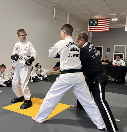 Instructor leading a teen and adult sparring drill